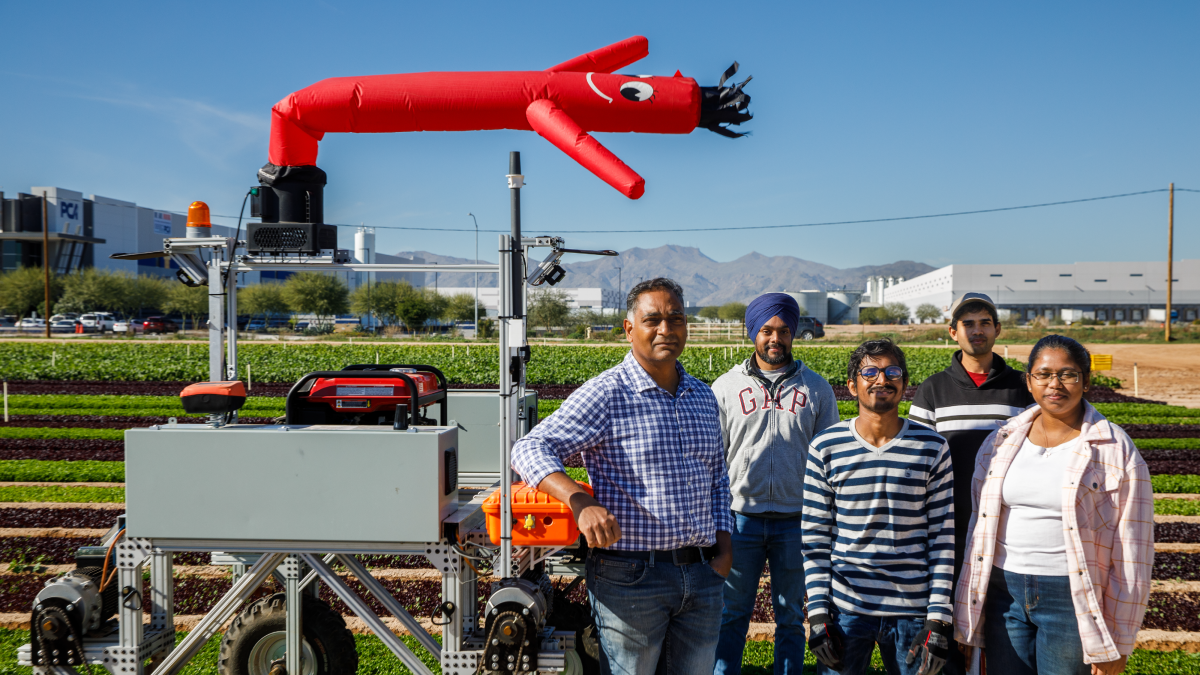Padma AgRobotics team standing beside their mobile AI-powered scarecrow in a vegetable field in Arizona.