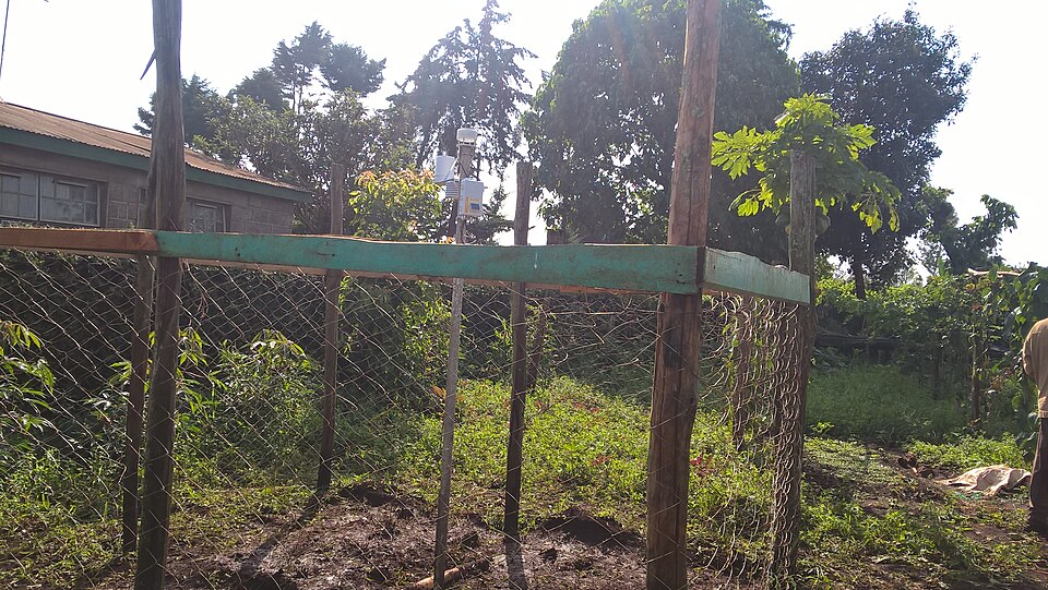 An automatic weather station inside a fenced enclosure at a farmer training centre in Kenya