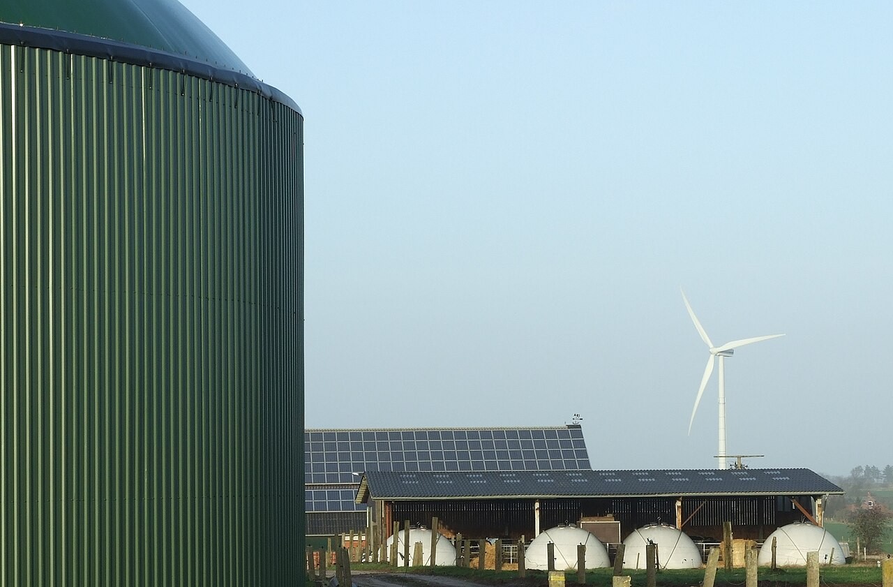 A rural energy installation combining biogas, photovoltaic panels and wind power.