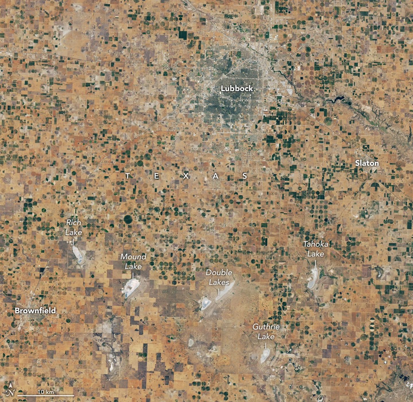 Landsat satellite image of dry agricultural fields and shallow lakes around Lubbock, Texas.