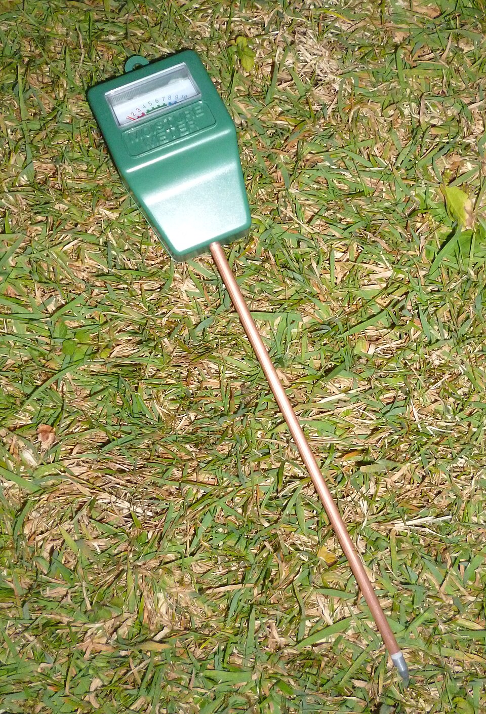 A conventional handheld soil-moisture meter with a probe and analogue dial