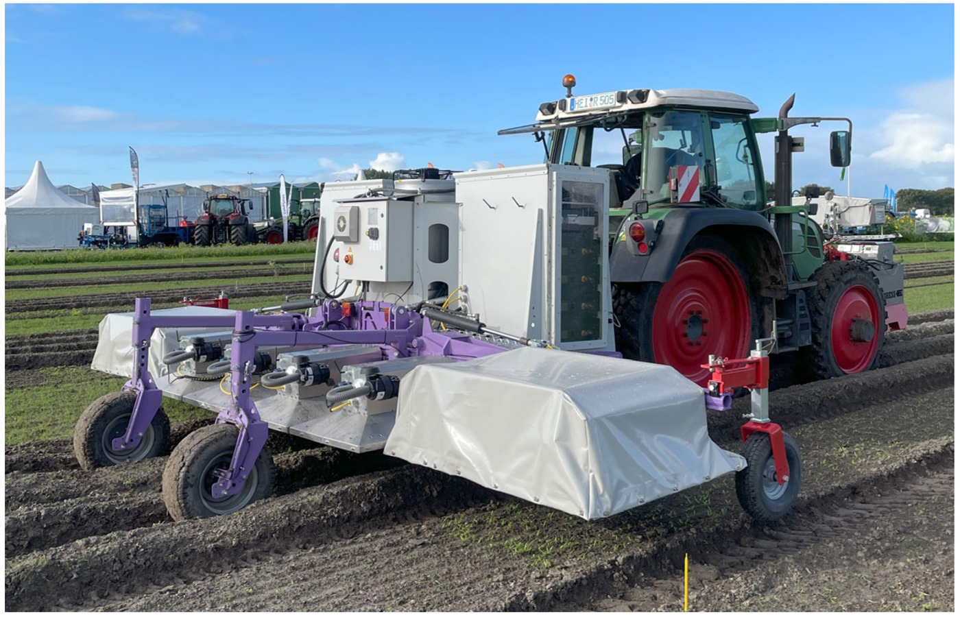 Tractor-mounted Naiture laser-weeding equipment at an outdoor demonstration.