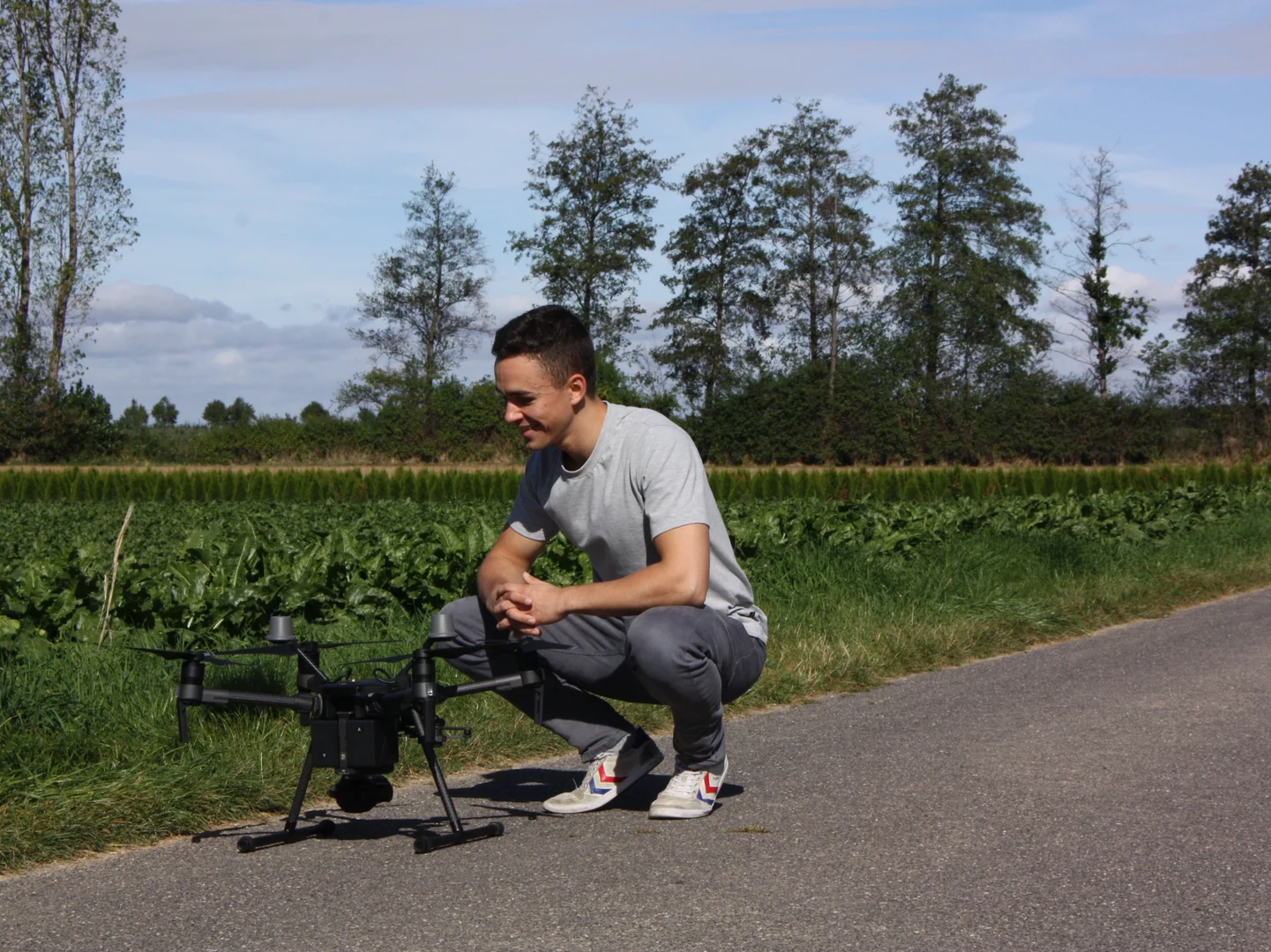 PhenoRob researcher Jan Weyler with field equipment and a drone.