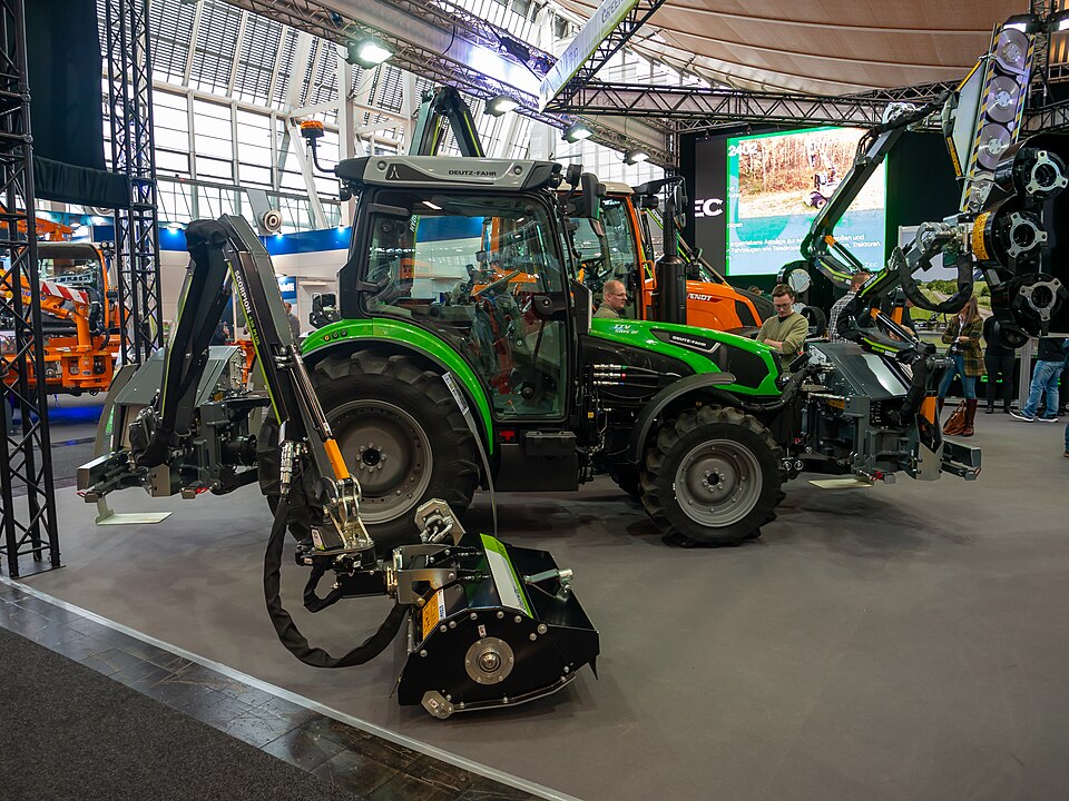 A tractor and attachments on an indoor exhibition stand at Agritechnica 2023.