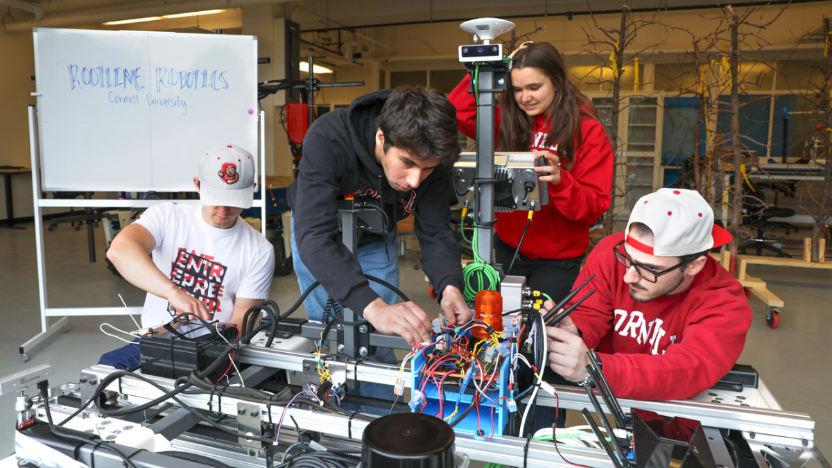 Cornell students working on the Rootline Robotics electric weeding prototype in a university laboratory.