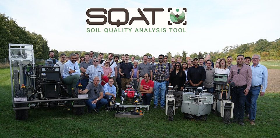 SQAT field-day participants posing beside soil mapping and sampling equipment.